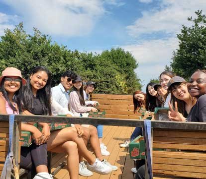 students on a truck in apple orchard